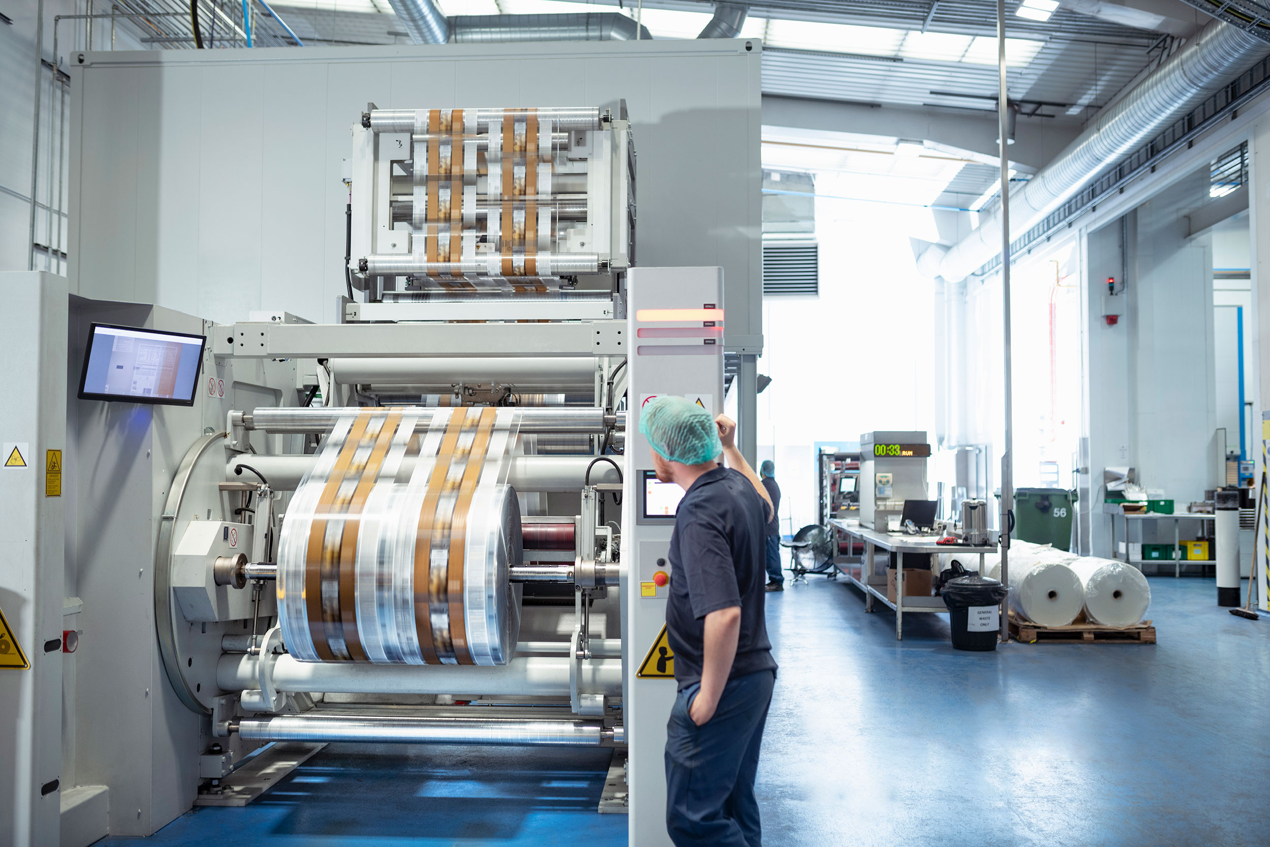 A worker operates an industrial machine