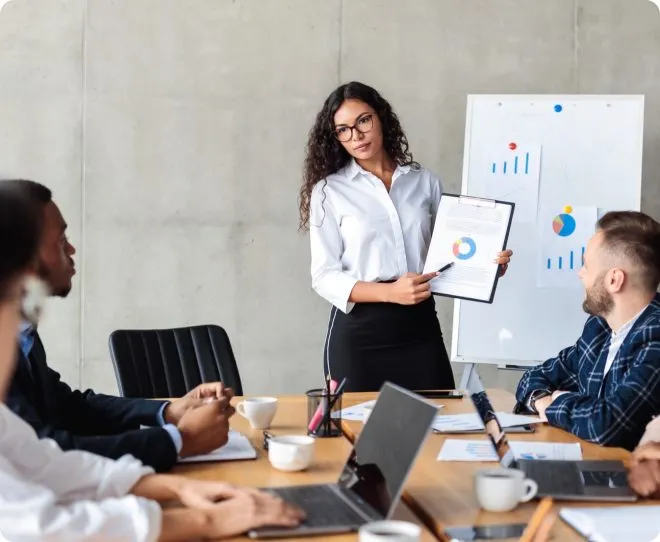A young professional giving a presentation to the team using charts.